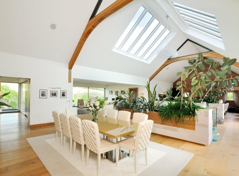High vaulted ceilings with wooden beams and windows lends the open-plan dining area a bright and airy feel, with plenty of room for both family and guests.