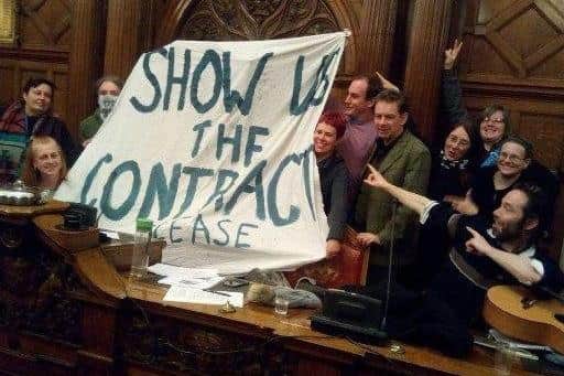 Street tree campaigners holding a banner that reads 'show us the contract' during a Sheffield Council meeting in the Town Hall.