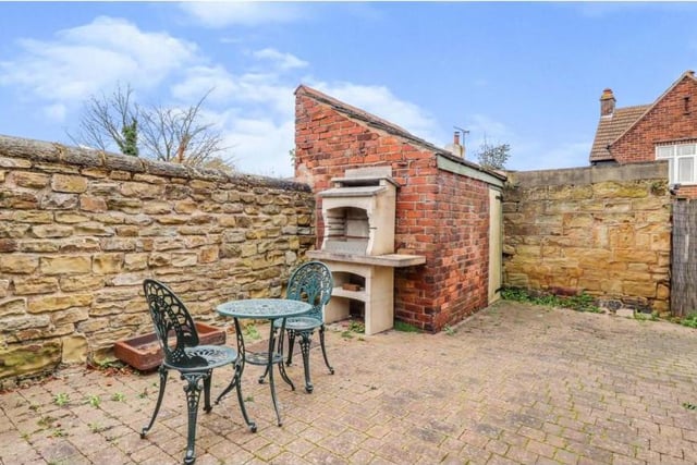 The charm of the Tibshelf cottage is summed up by this lovely courtyard, complete with brick-built barbecue, seating area and one of many outbuildings at the property.