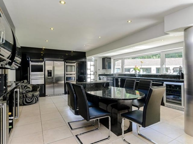The kitchen at Mount Charlotte is truly spectacular. It features a range of high-gloss, black base and wall units with a central island and breakfast table. A collection of high-quality, integrated appliances include and oven and warming drawer, induction hob, American-style fridge-freezer, dishwasher, wine cooler and TV unit.