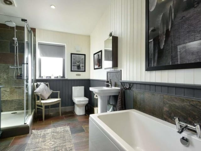 The bathrooms are beautifully designed, with separate baths and showers. This one has been designed with neutral colours of white and grey and a wonderful tiled flooring