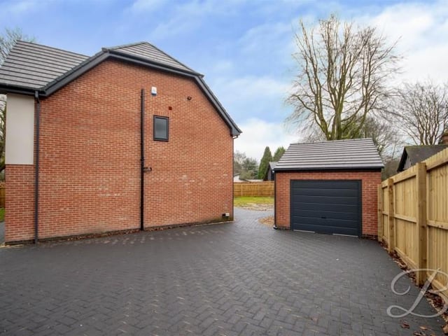 There is a garage and a large driveway.