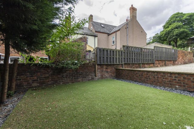 There is an artificial lawn  with decorative plum slate side borders at the rear of the property.