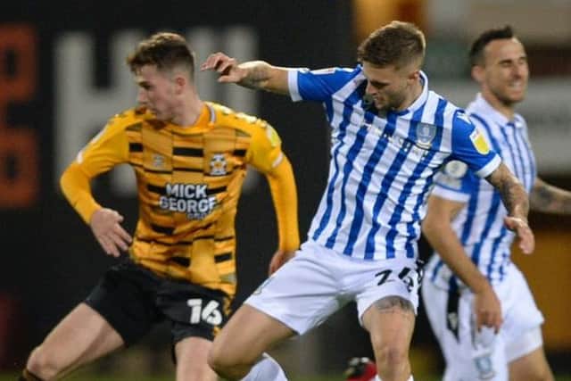 Sheffield Wednesday's Lewis Wing battles for a ball against Cambridge United.
