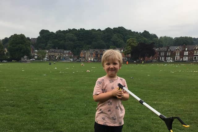 Four-year-old Finn Hackett collecting rubbish in Endcliffe Park, Sheffield, with his dad, Ben