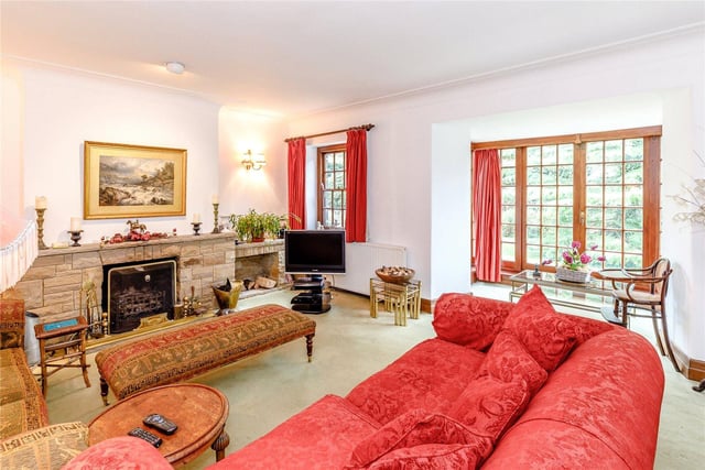 The formal sitting room features a stone fireplace at its heart and is bathed in plenty of light from the bay windows which incorporates French style patio doors leading to the garden.