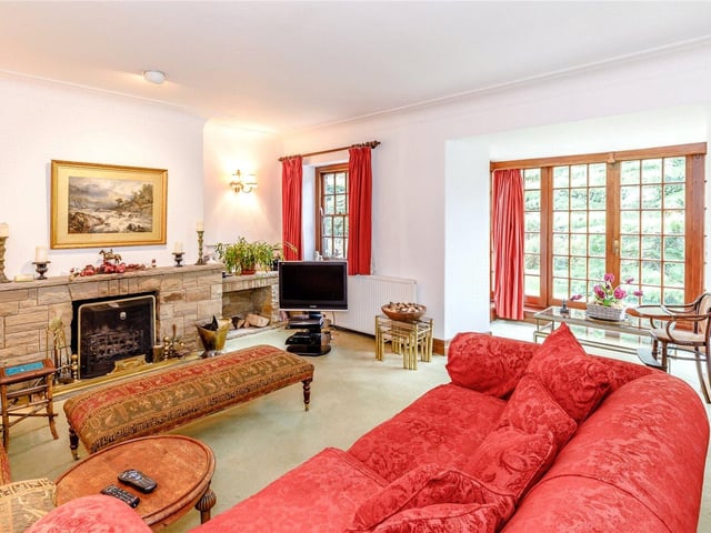 The formal sitting room features a stone fireplace at its heart and is bathed in plenty of light from the bay windows which incorporates French style patio doors leading to the garden.