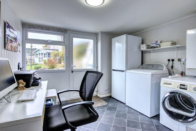 A useful office/utility room with space for white goods and doors leading in to the rear garden.