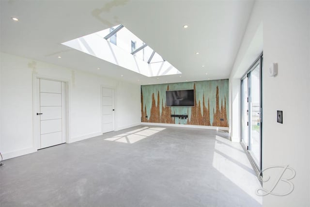 The dining room can only be described as spectacular, especially with its skylight, allowing natural light to flood in. Its bi-folding doors lead into the garden.