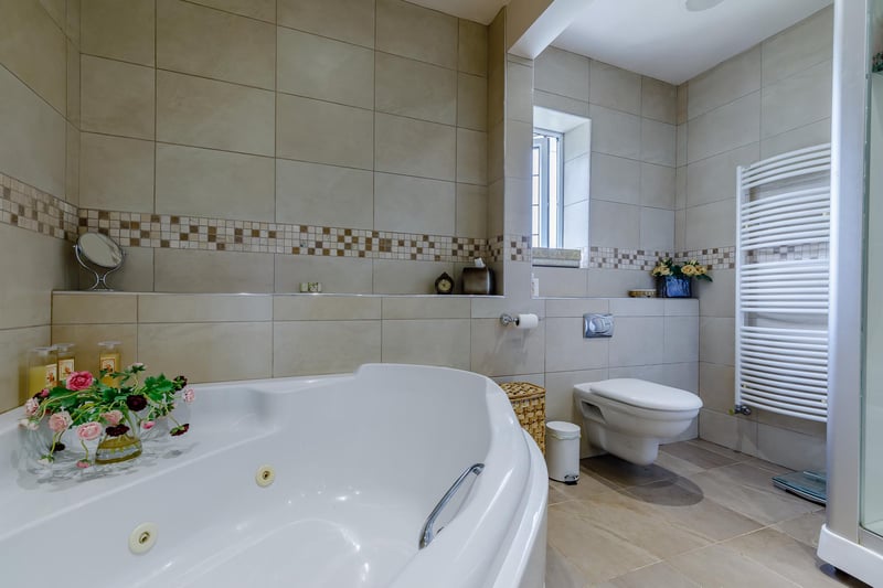 The four-piece en-suite has Jacuzzi bath, WC, wash hand basin and a double shower enclosure with massage jets