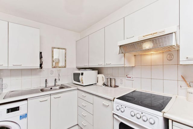 The kitchen features a number of integrated appliances, including a freestanding electric cooker, fridge and a washing machine.