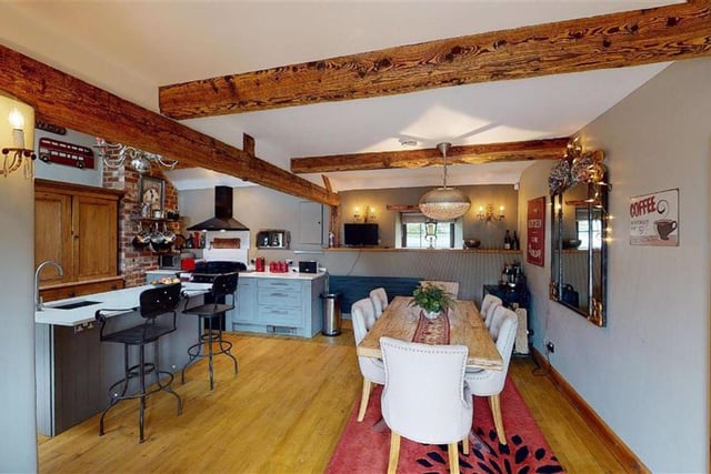 There are exposed beams and enough room for a large table.