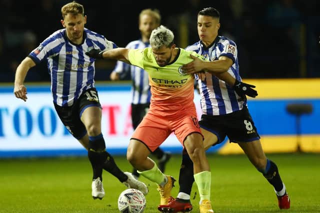 Sergio Aguero of Manchester City battles for possession with Tom Lees and Joey Pelupessy of Sheffield Wednesday during the FA Cup Fifth Round match between Sheffield Wednesday and Manchester City at Hillsborough on March 04, 2020 in Sheffield, England. (Photo by Clive Brunskill/Getty Images)