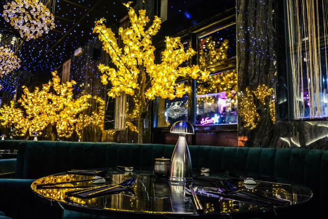 Customers are seated between illuminated Maple trees, where they can relax in the immersive surroundings.