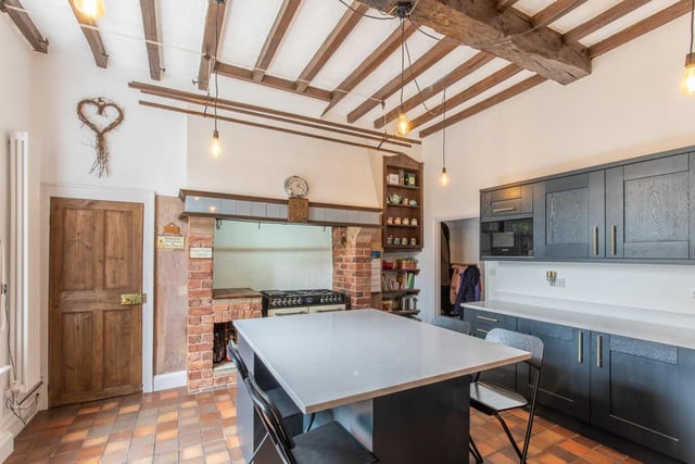 The breakfast kitchen has a Quarry tiled floor, a sash window with shutters overlooking the courtyard and a high ceiling height with exposed beams. A rustic brick chimney breast is home to a Kensington stove, comprising a double oven and grill, with a seven-ring burner and a concealed extraction unit over.