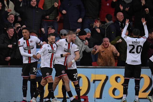 Sheffield United's striker Oli McBurnie (C) is mobbed by teammates after scoring the opening goal during the English FA Cup fourth round football match between Wrexham and Sheffield United at the Racecourse Ground Stadium in Wrexham, north Wales: OLI SCARFF/AFP via Getty Images