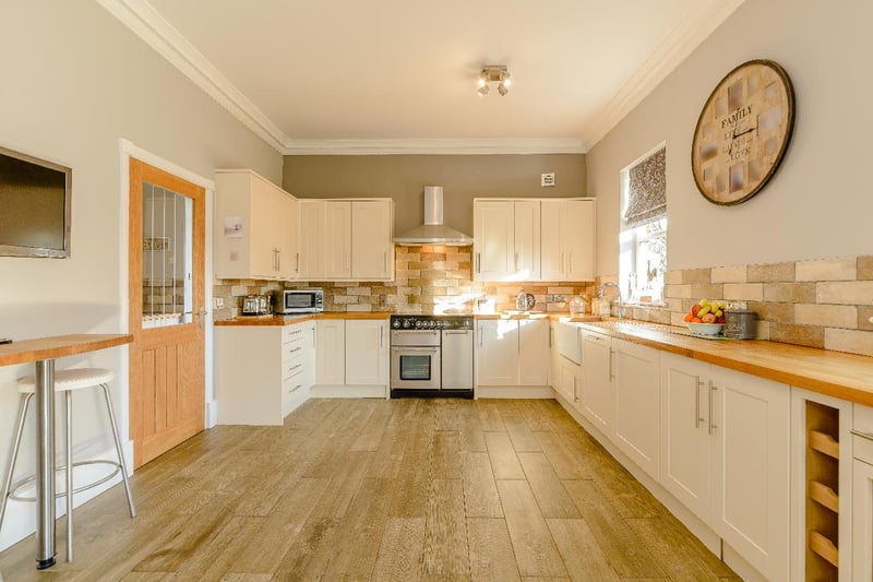 The generously proportioned kitchen, fitted with an extensive range of units and appliances, provides ample space for informal dining.