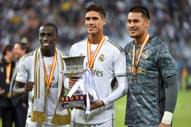 Real Madrid's French players Ferland Mendy (L), Raphael Varane, and Alphonse Areola (R) pose with the cup after winning the Spanish Super Cup final between Real Madrid and Atletico Madrid on January 12, 2020, at the King Abdullah Sports City in the Saudi Arabian port city of Jeddah.