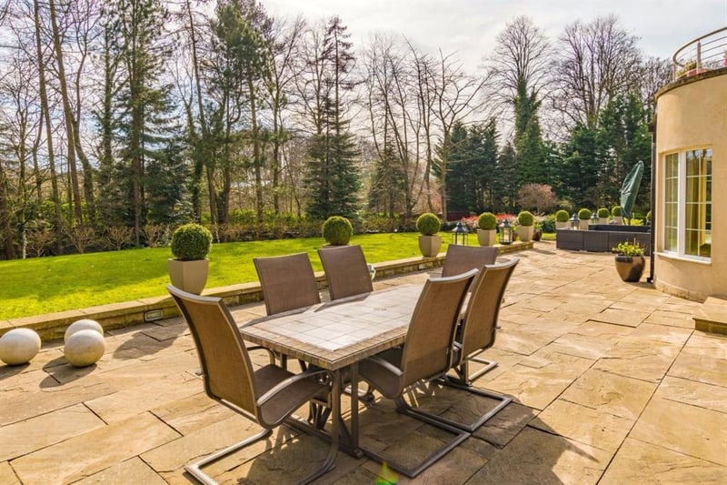 The stone paved sun terrace sweeps around the house, providing an ideal spot for al fresco dining with views across the gardens.