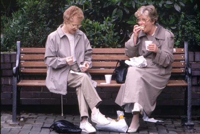 Two women stop on a park bench for a sandwich and a cup of tea in Glasgow in August 1990.