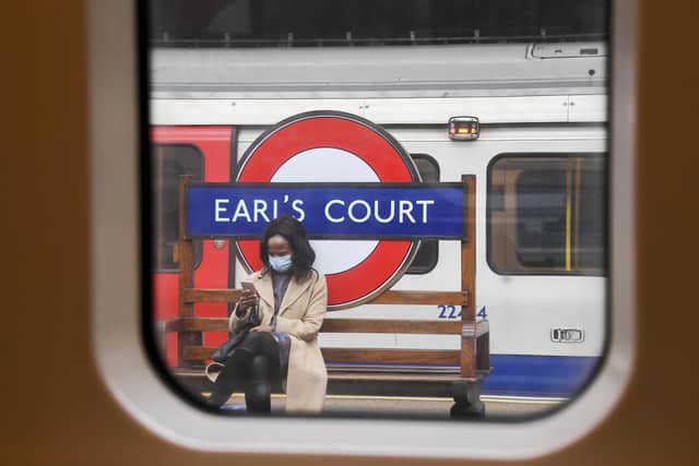 A woman sits on a bench at Earl's Court underground station, wearing a mask as the lockdown due to the coronavirus outbreak continues: AP Photo/Alberto Pezzali