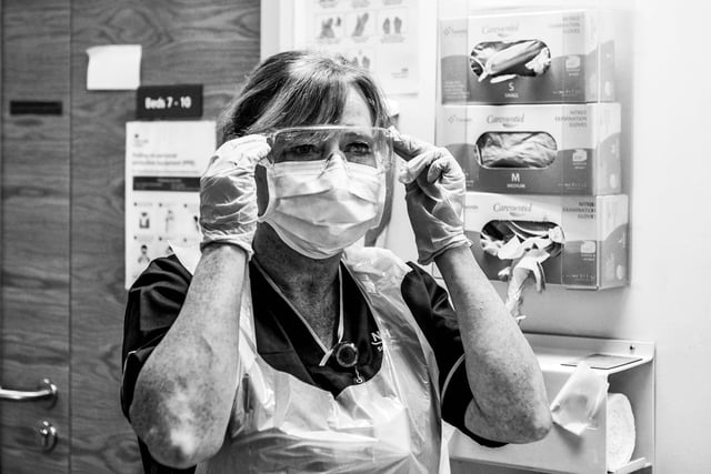 Senior charge nurse Donna Read putting on PPE before going to attend to a patient.