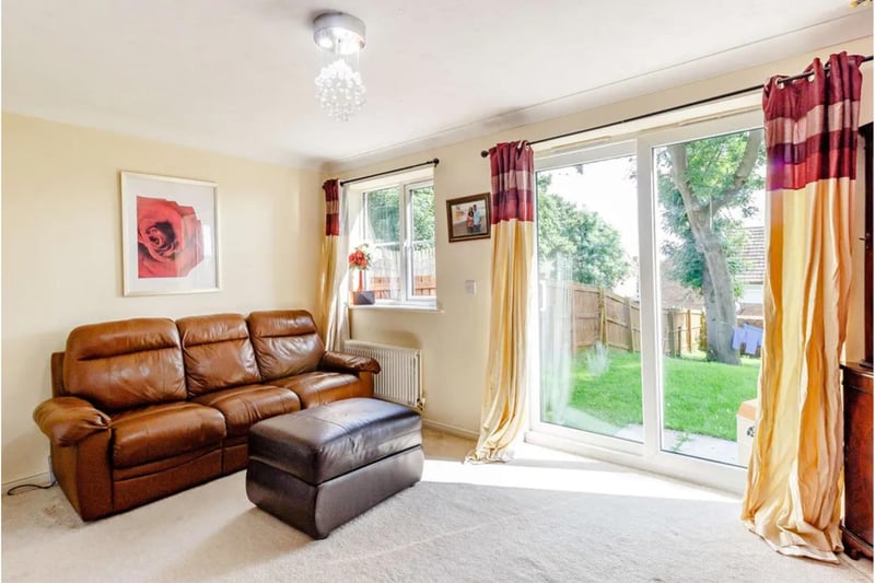 The living room is full of light from a large door for access to the rear garden.