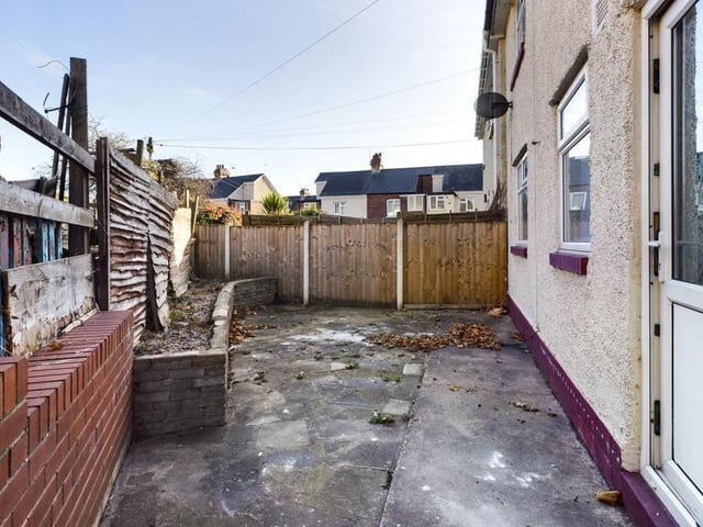 Rear garden - Fence enclosed, paved with raised flower bed.