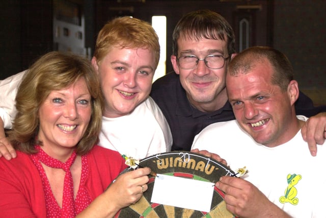 Tina Codd, left, the community fund raiser for the childrens appeal at Sheffield childrens hospital receives a cheque for £445.00 from Frank Dunnill, right after a 12 hour darts marathon at his local, Thawleys, Station Road, Wombwell, Barnsley. Frank raised the money after his daughter Sherry Louise died through a rare blood disorder. Pictured in 2000 with them are two of the six people who took part in the fundraiser and they are, Sam Appleby and Kevin Byron.