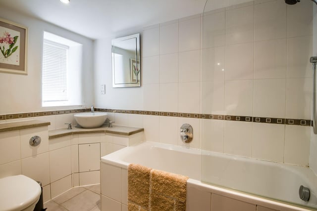 There's a bath with a shower, a low flush WC and a contemporary circular sink in the en-suite.
