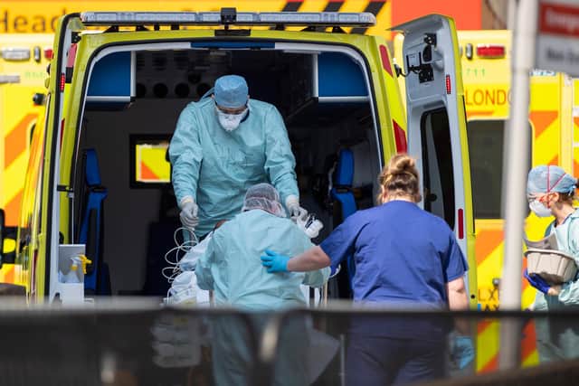 NHS workers in PPE take a patient with an unknown condition from an ambulance   (Photo by Justin Setterfield/Getty Images)