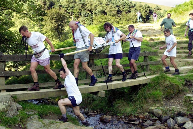 Members of the Edale Field Head rangers team  carry their barrel over a stream on their way to the finish of the Great Kinder Beer Barrel challange race between the Snake Inn  on the Snake Pass over Kinder Scout to finish at the Old Nag's Head in Edale in 2003