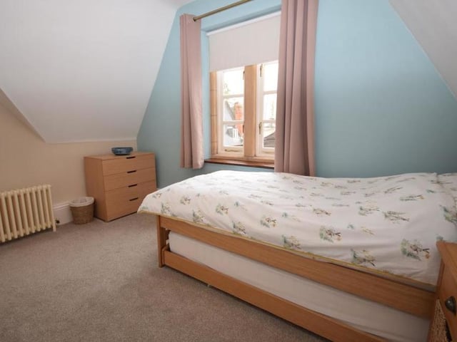 The second bedroom is nicely decorated with calming tones. Views look across the private courtyard, around which the home is wrapped.