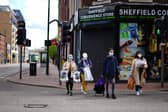 People wearing face coverings walk through Sheffield city centre.