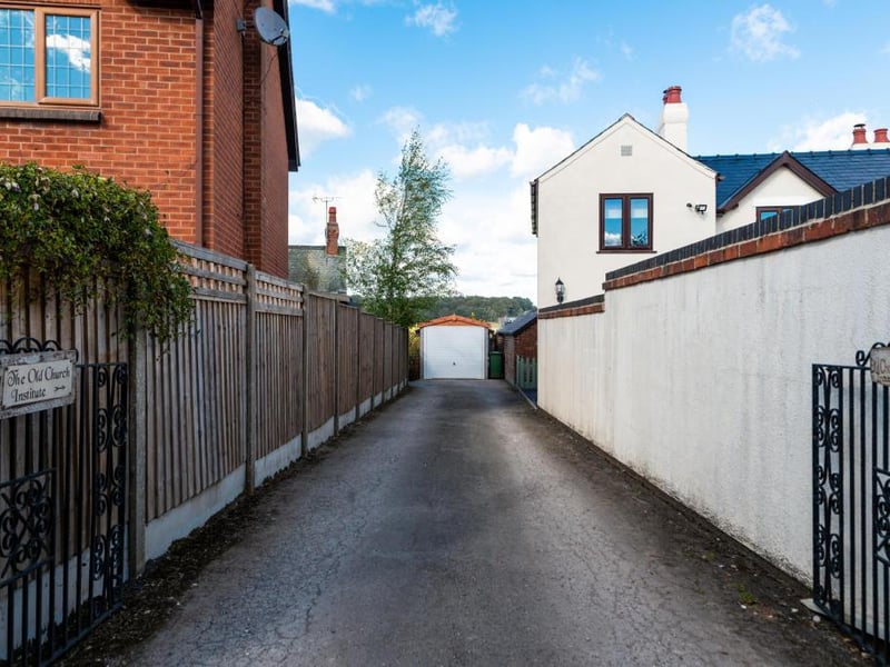 To the front of the property is a generous driveway providing ample off-road parking, leading to a garage.