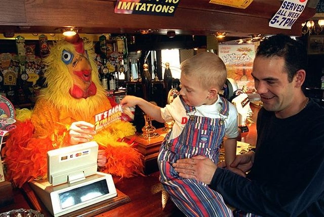 Queens Head pub waitress Jan Davey, is dressed up as a chicken to promote the pubs services. Seen is Daniel Gillan with his dad Gordon Gillan taking a promotional leaflet on September 16, 1996