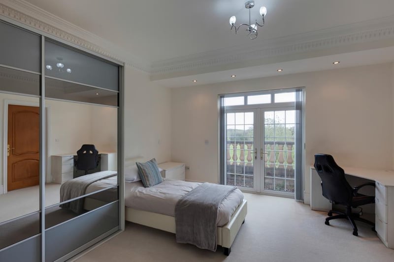 Bedroom four, on the first floor, boasts a range of fitted furniture, incorporating short hanging and shelving, as well as double upvc doors opening to a balcony.