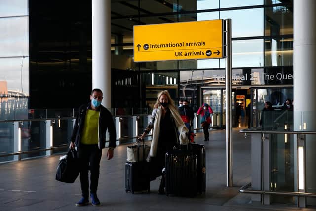 Travelers arrive at Heathrow Airport (Photo by Hollie Adams/Getty Images)