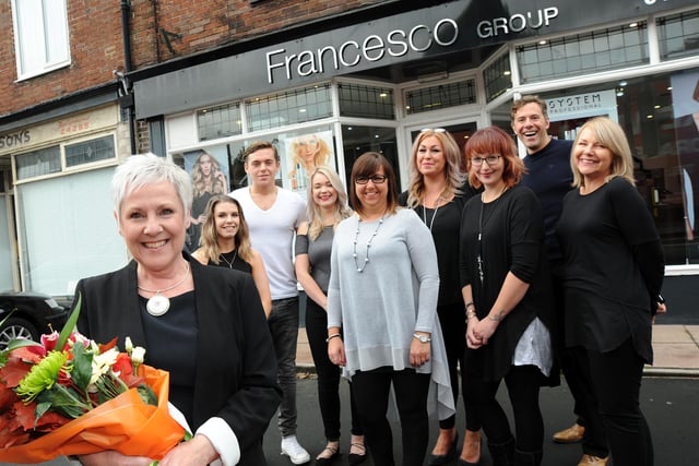 Debbie Stubbs, pictured after the presentation of flowers and plaque to mark the handover of her franchised hairdressing business, Francesco Group, to new owner, Helen Derbyshire, fifth right, by managing director, Ben Dellicompagni, second right, at the Dale Road salon in Buxton in 2016