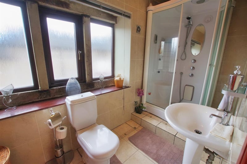 Double glazed stone mullion windows to rear, steam/shower cabin, WC and wash hand basin.