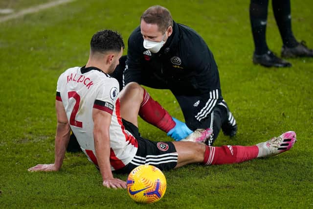 Sheffield United's defender George Baldock receives treatment after picking up an injury against West Brom (Photo by TIM KEETON/POOL/AFP via Getty Images)