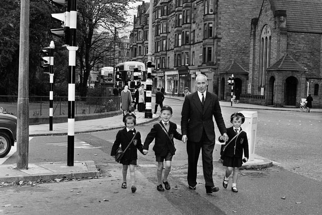 Councillor John Fitzpatrick helps children over the road at Holy Corner, in Morningside, in 1964.
