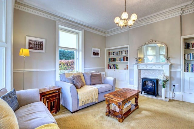 A sitting room with bay window overlooking the front and fitted book shelves.