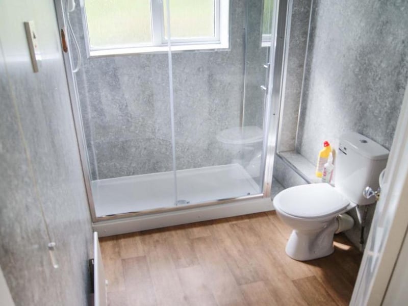 Fully panelled bathroom with three piece suite, wash hand basin with mixer tap, fully enclosed double shower cubicle and WC, extractor fan, window provided natural light and ventilation, central heating radiator and low maintenance flooring