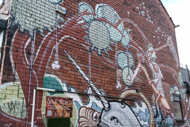 The opposite wall of the alleyway leading to Silk Road Gallery, this one adorned by a narwhal, octopus, and a strange figure riding astride a crane.