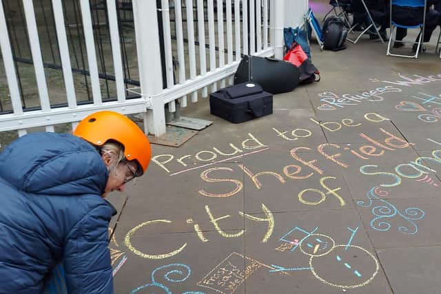Public artwork on the street outside Sheffield Town Hall reads "Sheffield city of sanctuary", and "refugees welcome here."