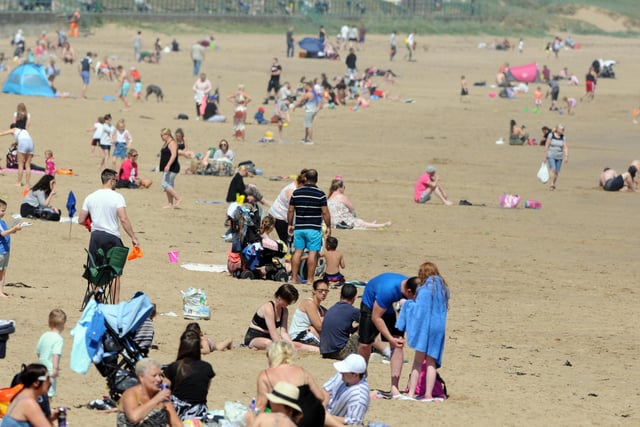 Families can be seen sat on the sand enjoying the hot weather.