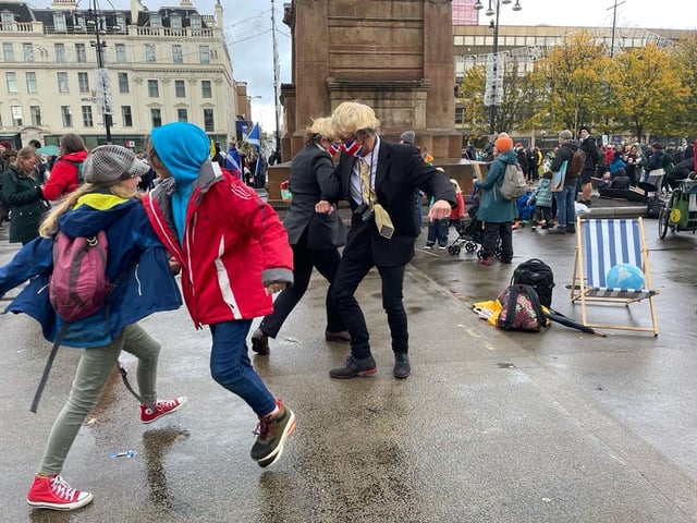 Protesters dressed up as Prime Minister Boris Johnson dancing in George Square.