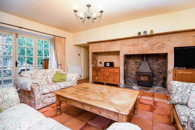 An original stone fireplace contains an inset multi-fuel stove while the opposite wall has exposed stonework. There are French doors and windows to both the rear, the side and the orangery.