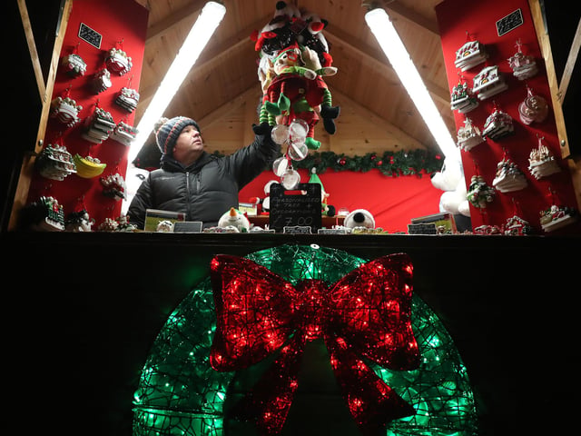 Gareth Thomas adjust Christmas decorations at the festive market at Blair Drummond Safari Park near Stirling, Scotland. Alongside the market visitors can enjoy the illuminations installed in the Safari Park's new 'World of Dinosaur' exhibit.